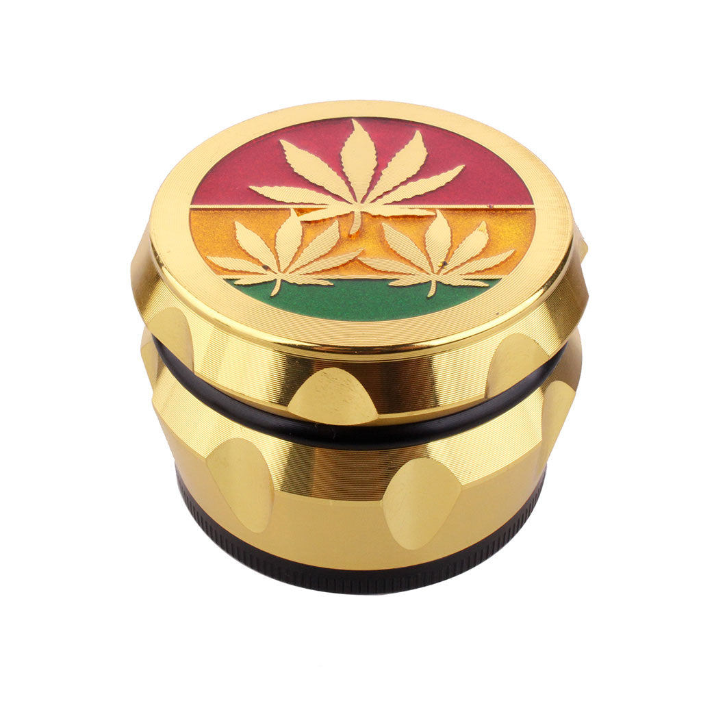 Gold-colored grinder with cannabis leaf design on a white background